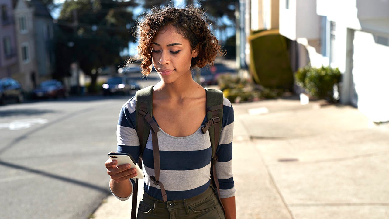 woman walking and looking at a phone