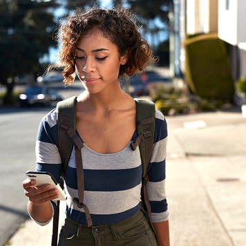 woman walking and looking at a phone