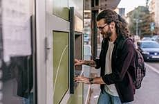 man using an atm on the street