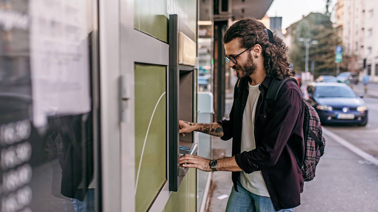 man using an atm on the street