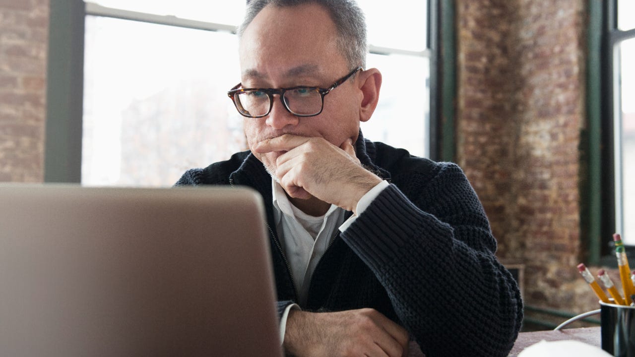 Man using laptop, with stern face