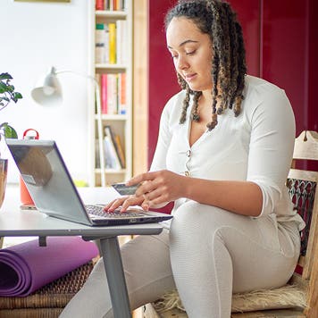 woman using a credit card at home`