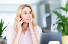 Woman talking on smart phone at home office