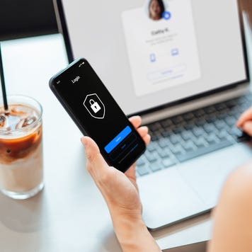 Woman using laptop, logging in online banking account with digital security device at cafe