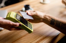 hand paying with credit card at contactless reader