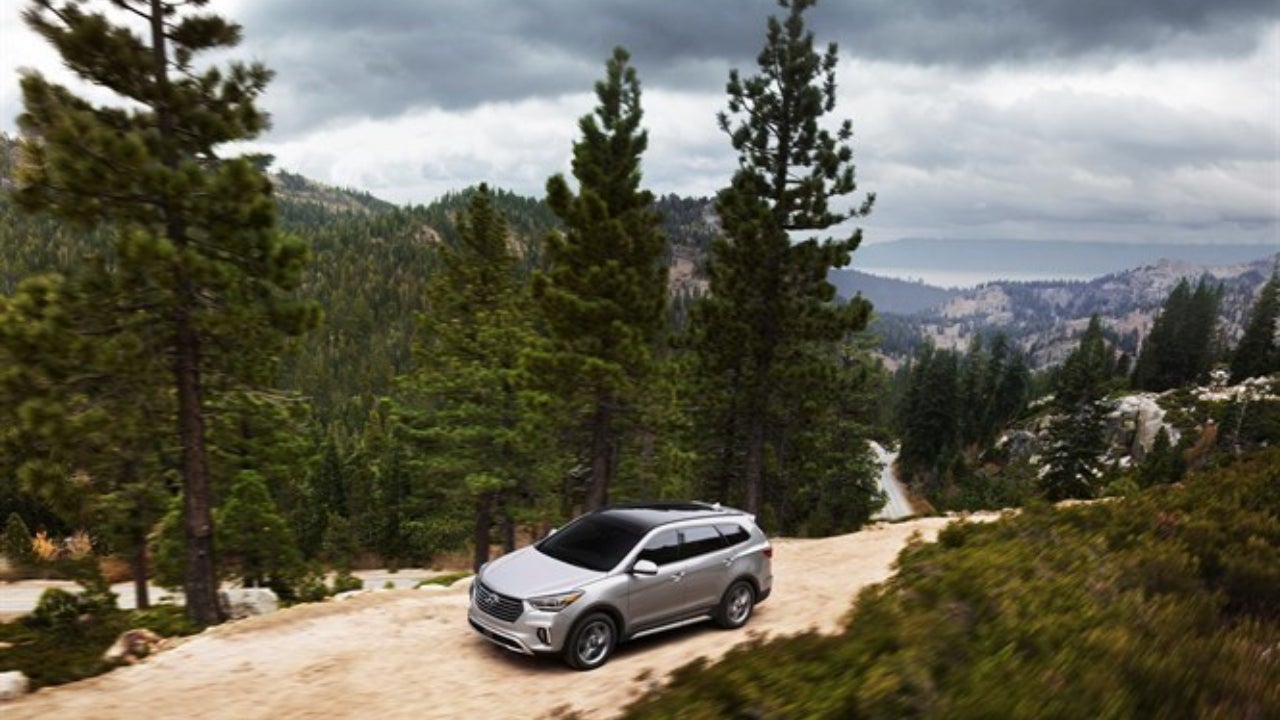 Gray Hyundai Santa Fe on a wooded mountain road