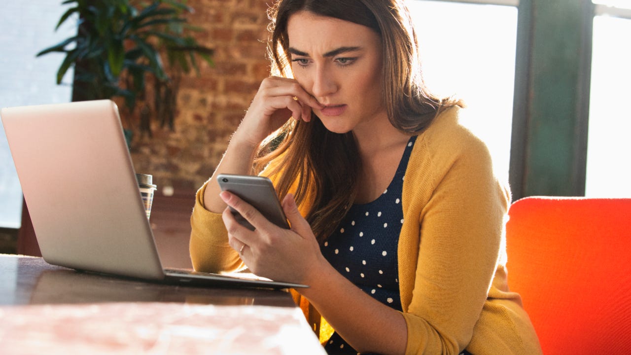 Stressed woman looks at phone