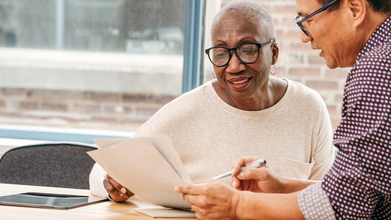 What is a probable sale - african american woman with gray hair going over paperwork with hispanic man