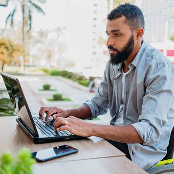 man working on his laptop outdoors