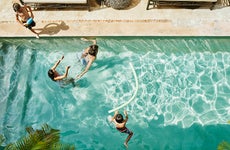 family playing in a pool at a resort