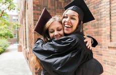 mother hugs daughter wearing a graduation hat
