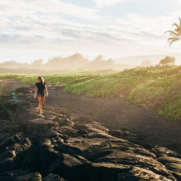 a girl walking on the coast in hawaii