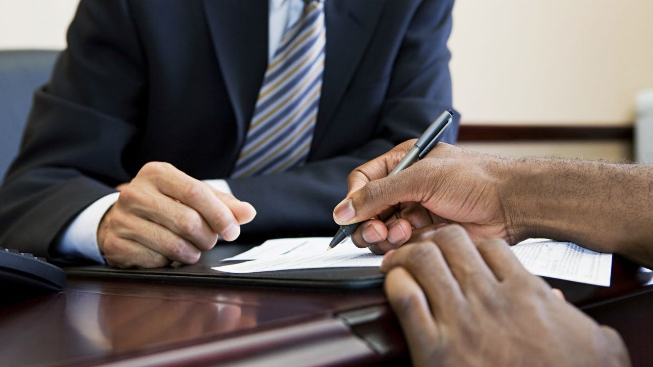 Signing loan paperwork at a bank