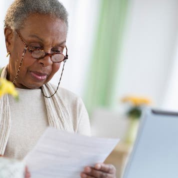 Woman looking at paperwork and her computer screen