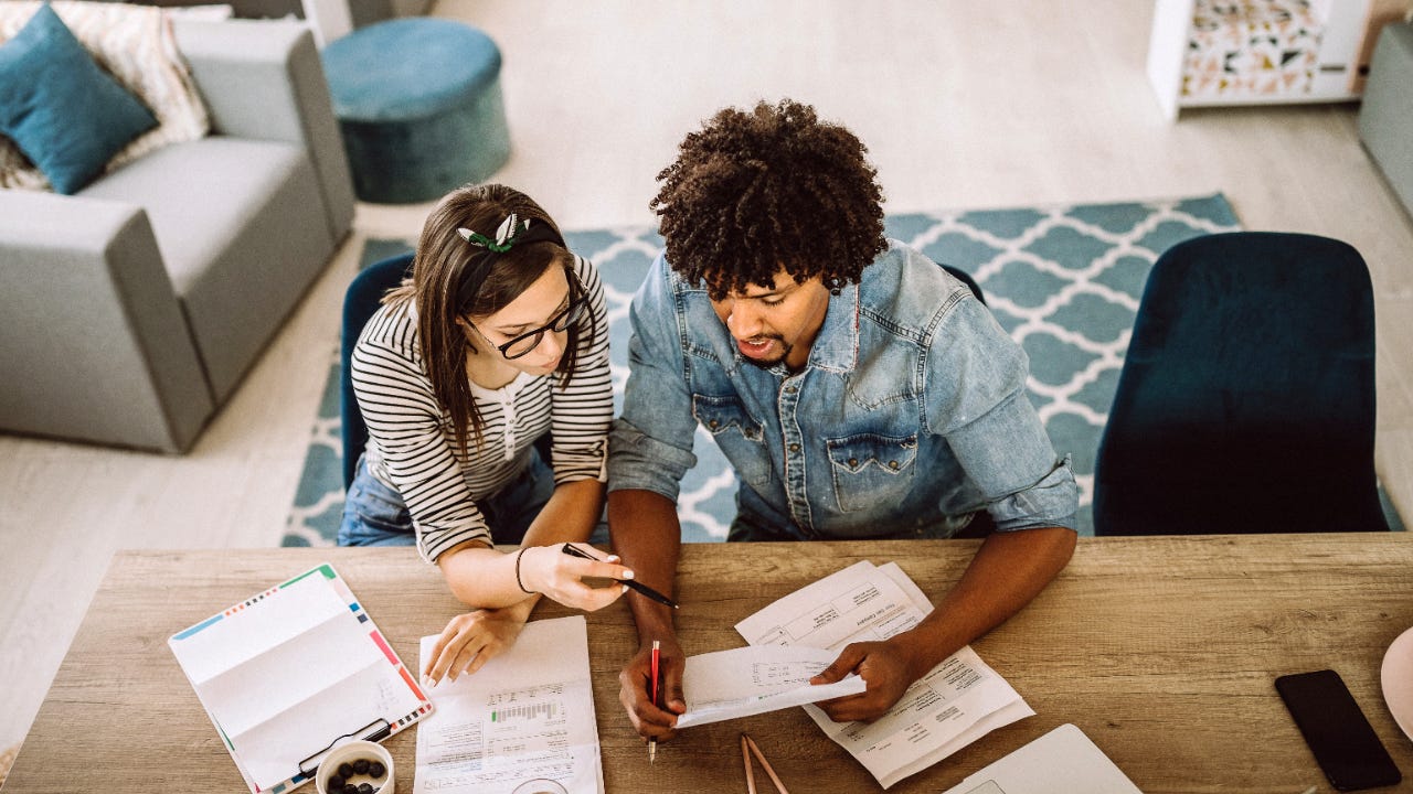 A couple looks over their investments at a desk at home