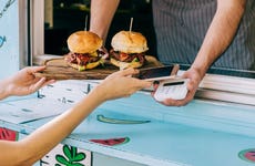 close up of hands using mobile payment for burgers from a food truck