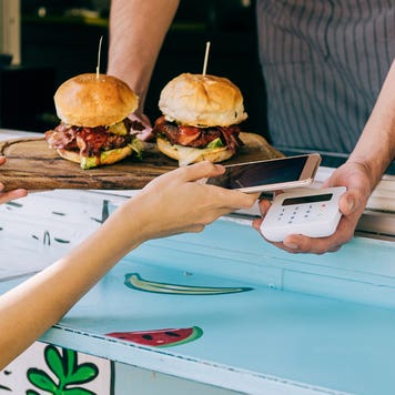 close up of hands using mobile payment for burgers from a food truck