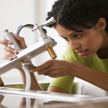 woman installing kitchen faucet