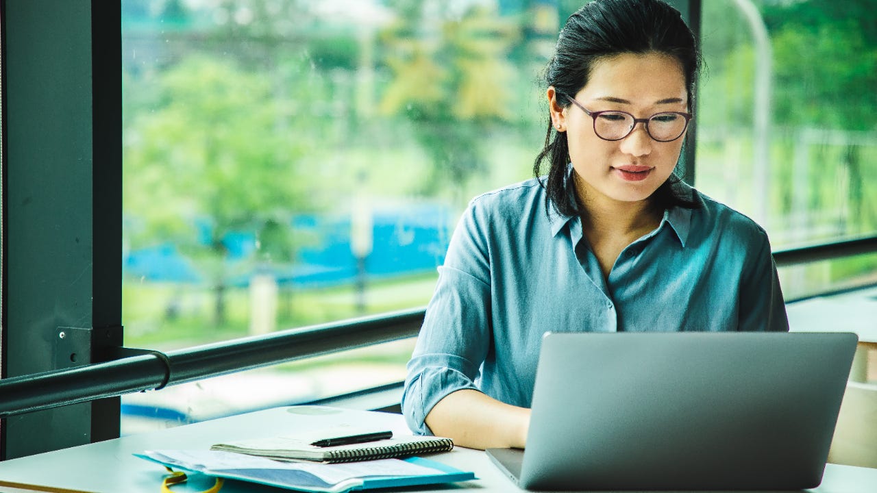 Asian woman works on laptop