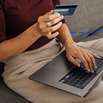 close up of hands paying with a computer
