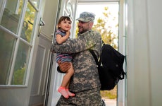 military father hugging his daughter when arriving home