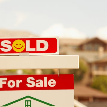 how to sell your house fast - red and white "sold" sign with yellow smiley face in front of suburban house
