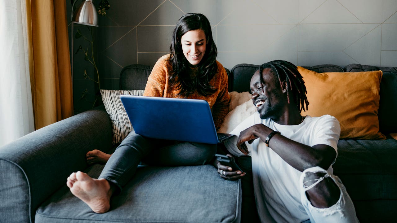 couple at home looking at laptop computer together