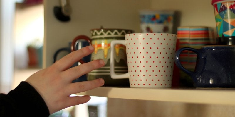 Reaching into a cabinet for a cup