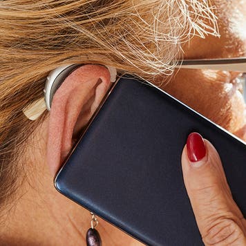 woman with hearing aid talking on the phone