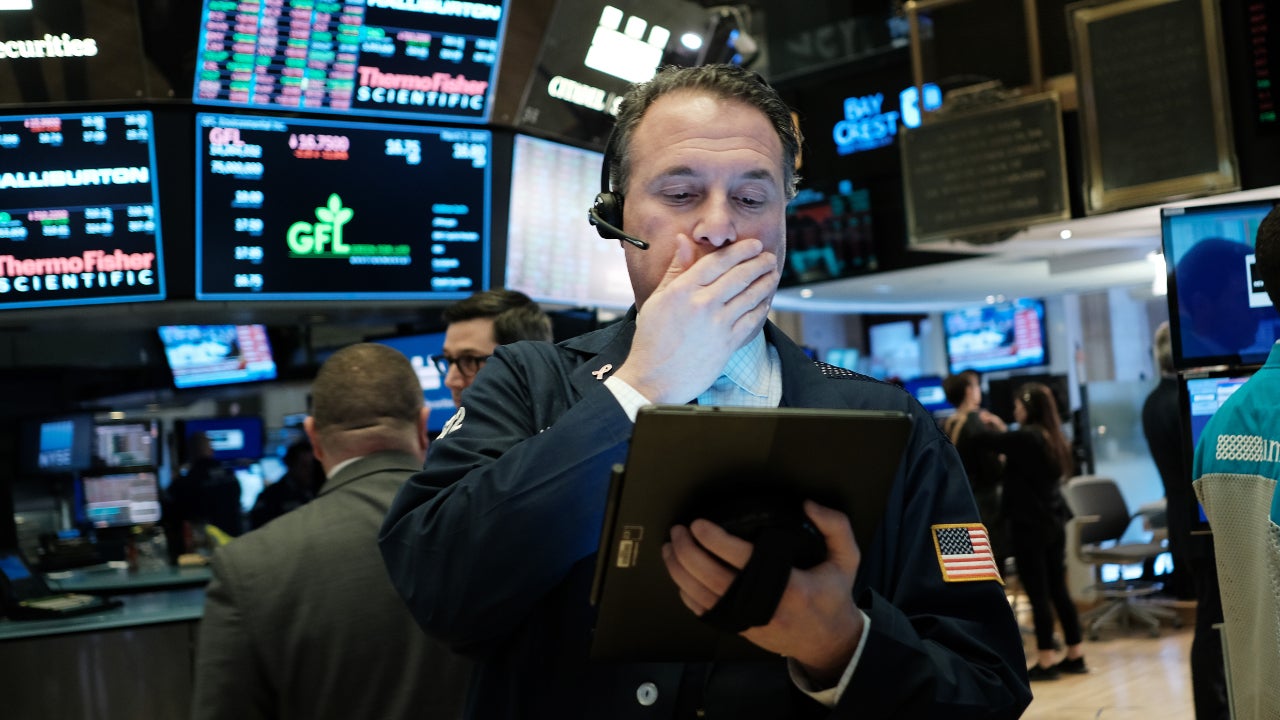 A trader on the stock exchange reacts with surprise