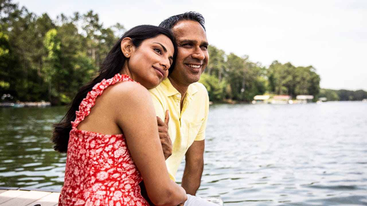 A couple looks out over a lake