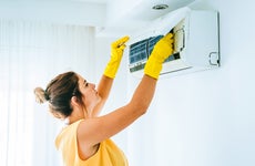 woman cleaning her air conditioner filter