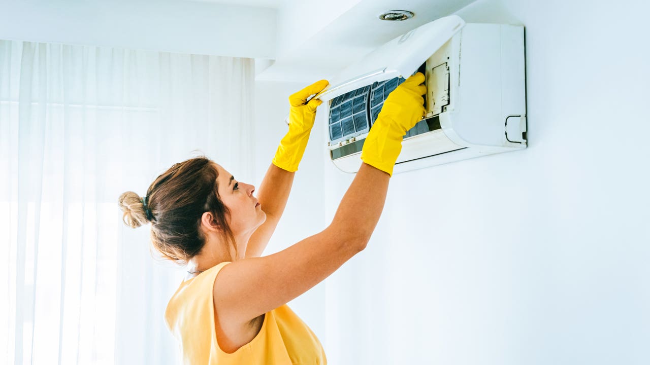 woman cleaning her air conditioner filter