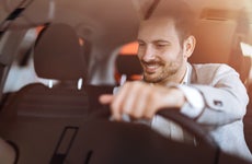 Man smiling and driving car