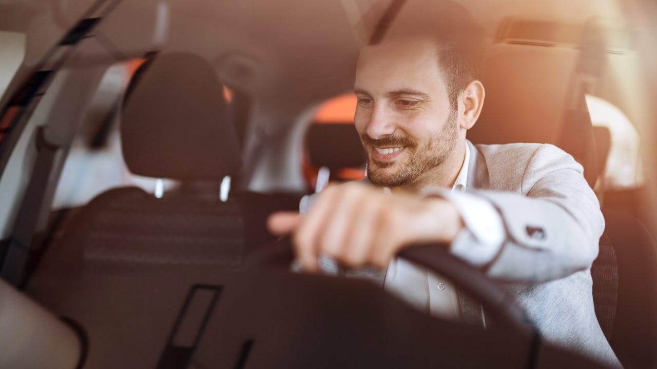 Man smiling and driving car