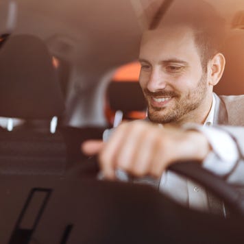 Man smiling and driving car