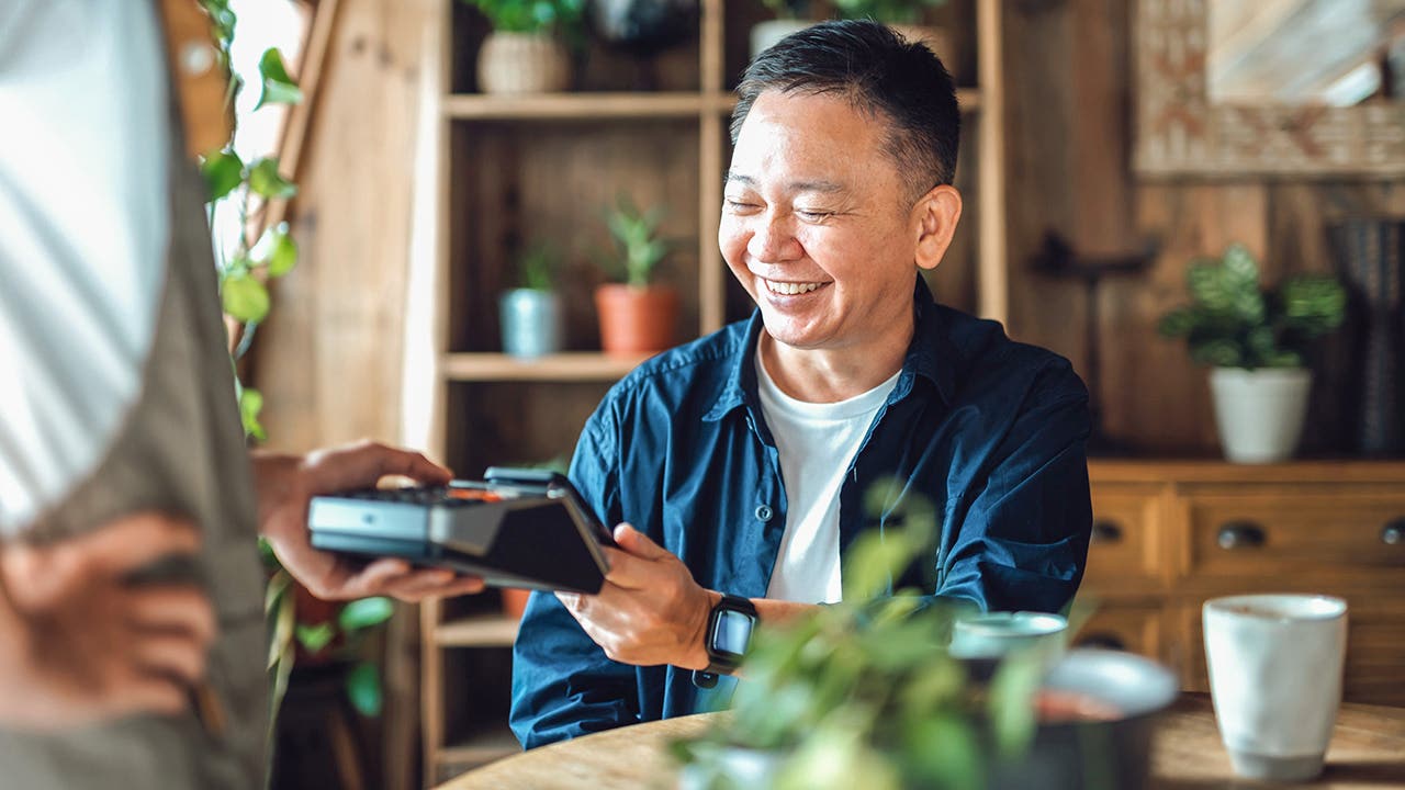 man using contactless payment at restaurant