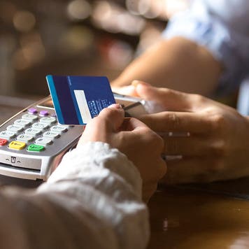 woman using tap to pay at a cafe