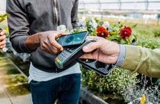 close up of man buying flowers and using mobile payment
