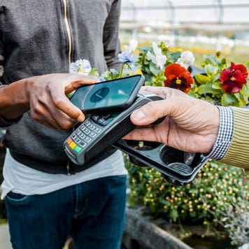 close up of man buying flowers and using mobile payment