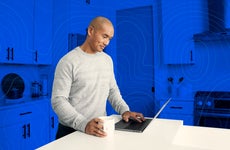 man working on his laptop in the kitchen