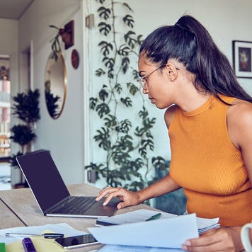young woman working on finances on her laptop at home