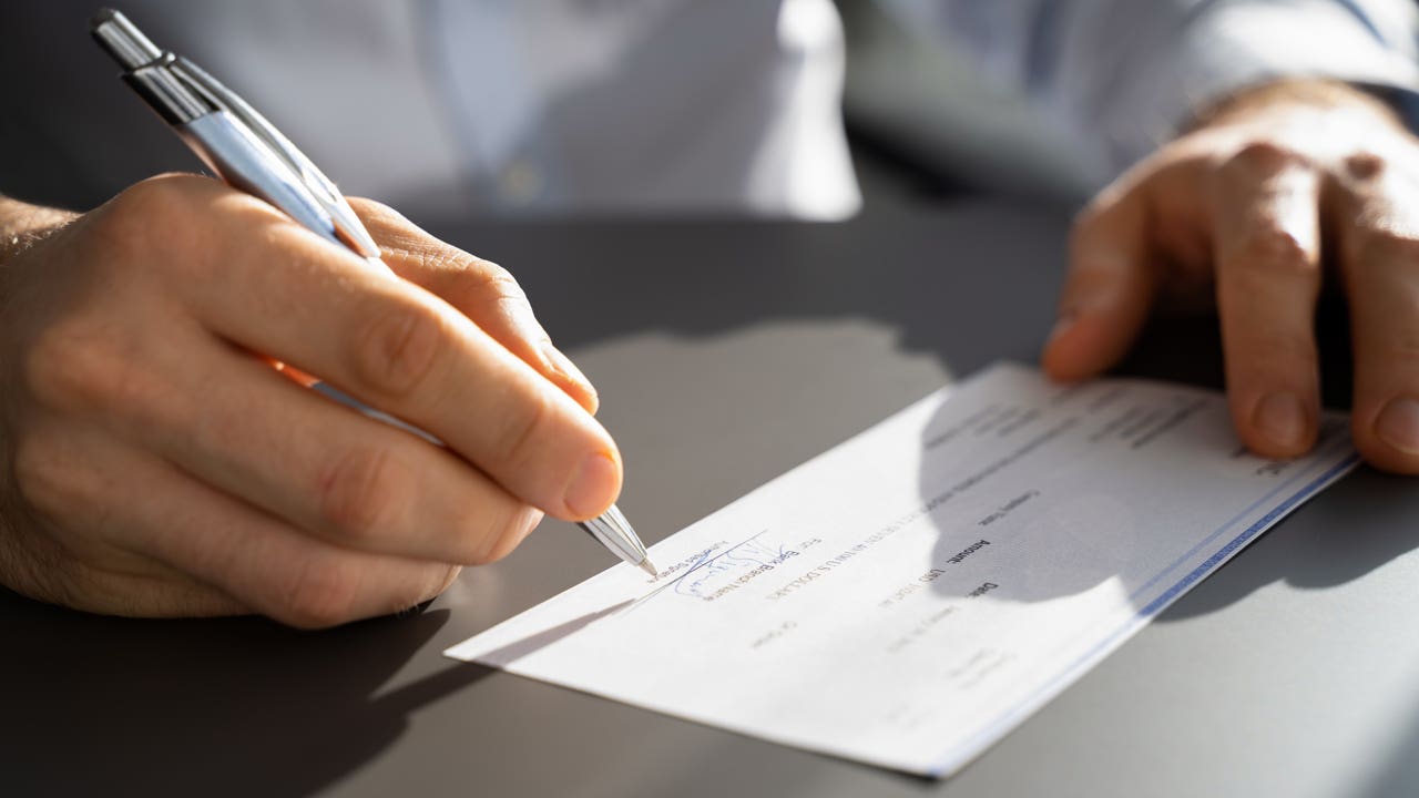 close up of hands signing a check