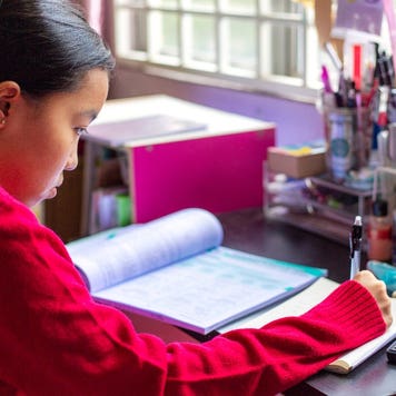 Student studies with a calculator at her desk