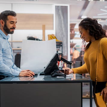 woman paying with mobile payment at a clothing store