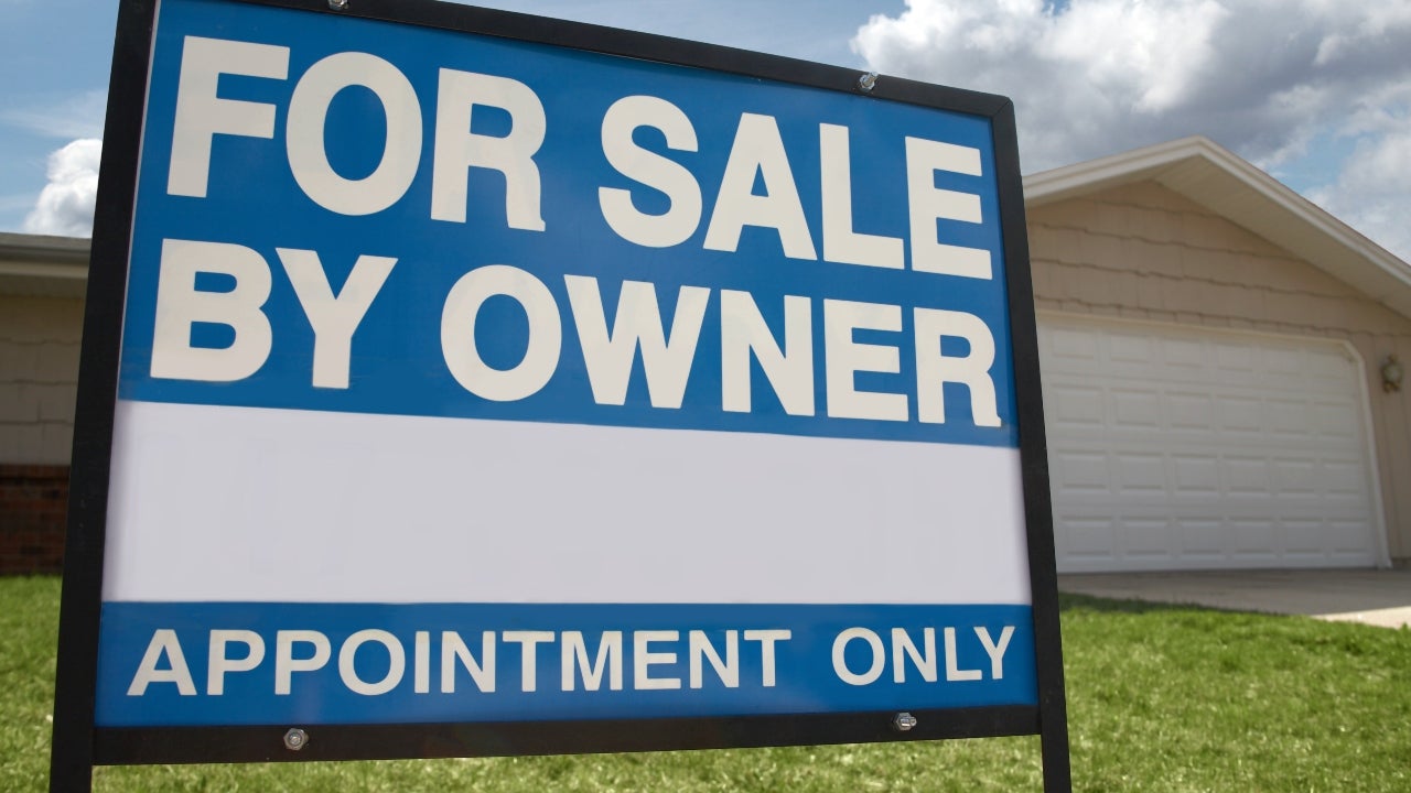 A closeup of a for-sale-by-owner sign