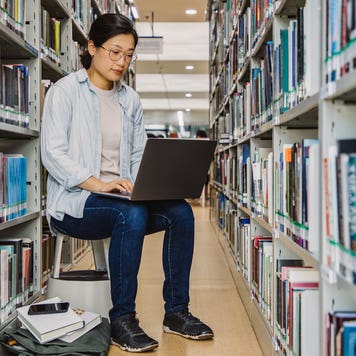 student working on her laptop in the library