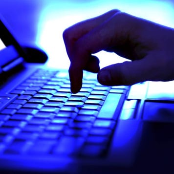 Hand on computer in the dark