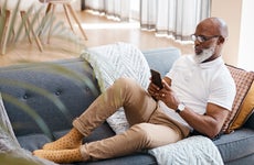 man sitting on the couch and looking at his phone
