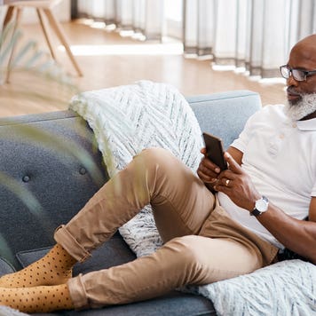 man sitting on the couch and looking at his phone